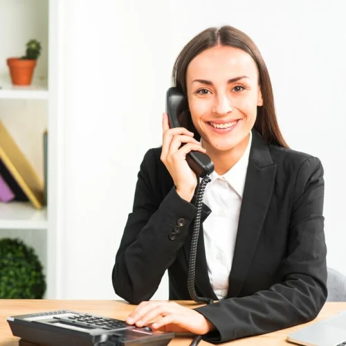 portrait-young-businesswoman-talking-telephone-looking-camera_23-2147943672